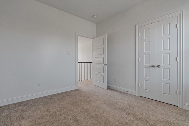 unfurnished bedroom featuring a closet, carpet flooring, and baseboards