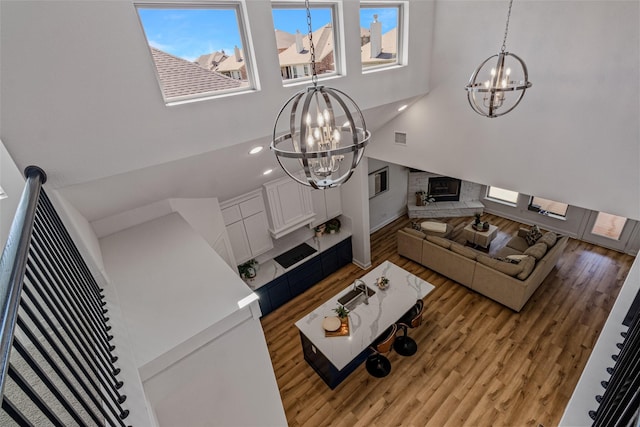 living area with a chandelier, visible vents, stairs, and light wood-style flooring