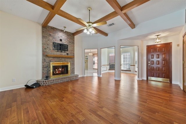 unfurnished living room with visible vents, a fireplace, baseboards, and hardwood / wood-style flooring