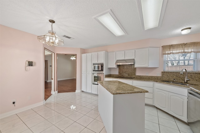 kitchen with under cabinet range hood, light tile patterned floors, appliances with stainless steel finishes, and white cabinets