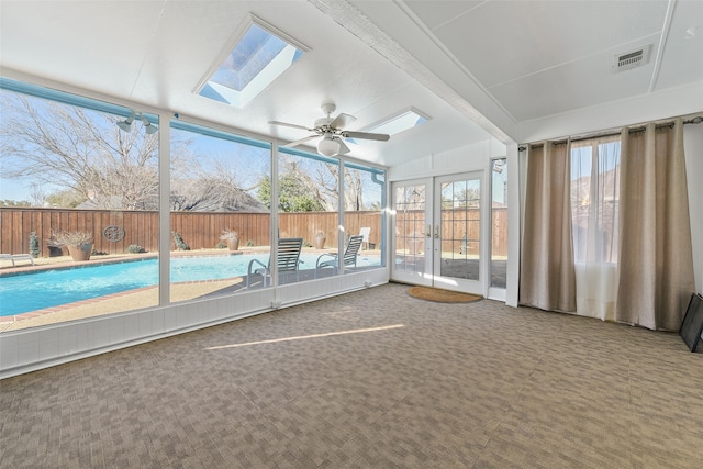 unfurnished sunroom with a skylight, visible vents, a ceiling fan, and french doors