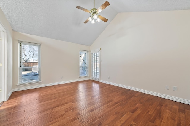 spare room featuring high vaulted ceiling, a wealth of natural light, baseboards, and wood finished floors