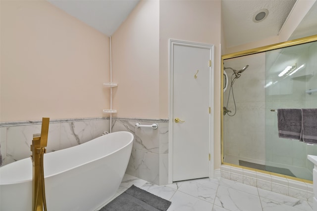 full bathroom with a stall shower, marble finish floor, wainscoting, and a freestanding bath