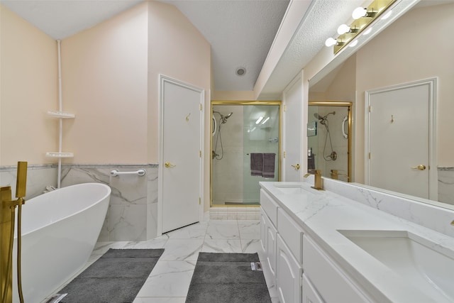 bathroom featuring marble finish floor, a shower stall, a freestanding tub, and a sink