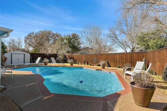 view of pool featuring a fenced backyard, an outbuilding, a fenced in pool, and a shed