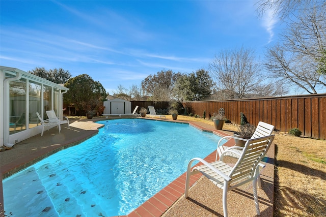 view of pool with a fenced in pool, a patio, a storage unit, a fenced backyard, and an outdoor structure