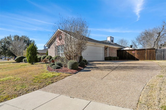 view of home's exterior featuring brick siding, concrete driveway, a lawn, an attached garage, and fence