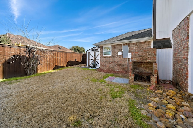 view of yard featuring an outbuilding, a storage unit, and a fenced backyard