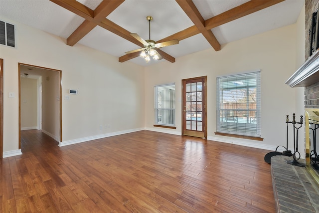 unfurnished living room with visible vents, baseboards, coffered ceiling, hardwood / wood-style flooring, and a brick fireplace