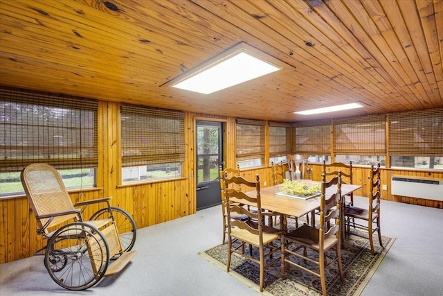 carpeted dining space with radiator, wooden ceiling, and wooden walls