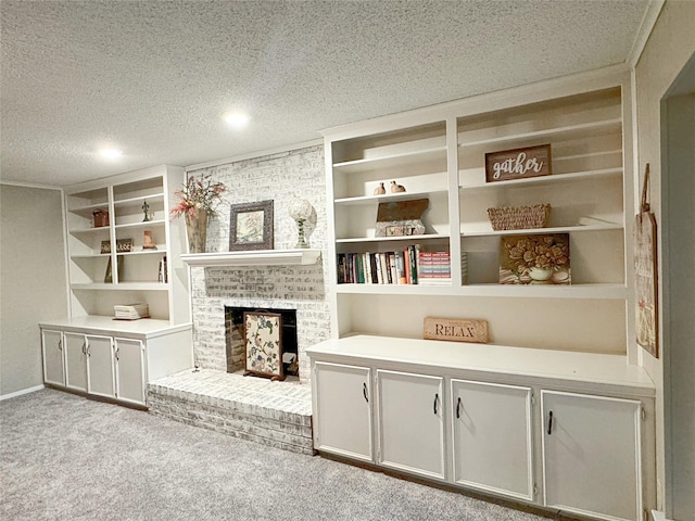 interior space featuring a brick fireplace, carpet, built in shelves, and a textured ceiling