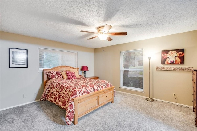 bedroom featuring carpet, baseboards, ceiling fan, and a textured ceiling