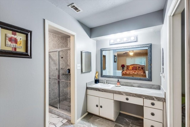 full bathroom with visible vents, a textured ceiling, a shower stall, ensuite bath, and vanity