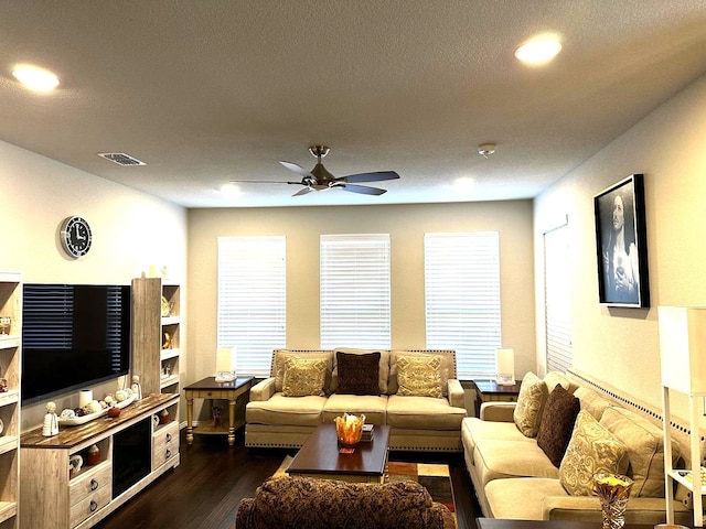 living area featuring dark wood-style floors, ceiling fan, visible vents, and recessed lighting