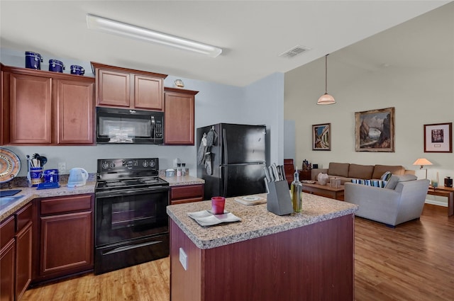 kitchen with light wood-style floors, light countertops, visible vents, and black appliances