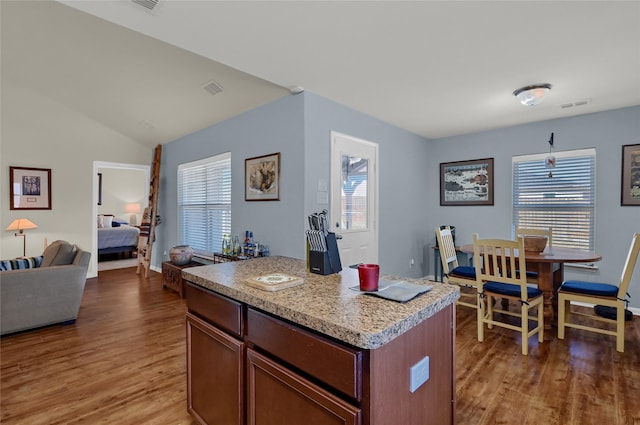 kitchen with open floor plan, a healthy amount of sunlight, visible vents, and light wood-style floors