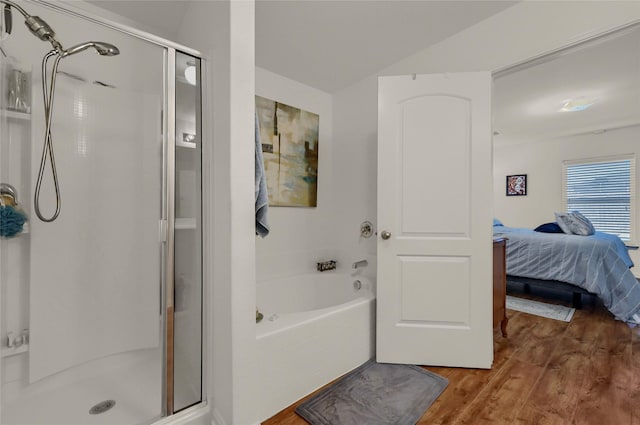 full bath featuring a bath, a shower stall, ensuite bath, and wood finished floors