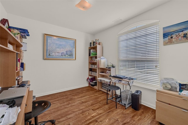 office area featuring wood finished floors, visible vents, and baseboards