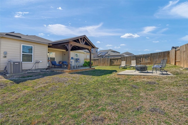 view of yard with cooling unit, a fenced backyard, a patio, and a fire pit