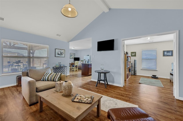 living area featuring high vaulted ceiling, visible vents, beam ceiling, and wood finished floors