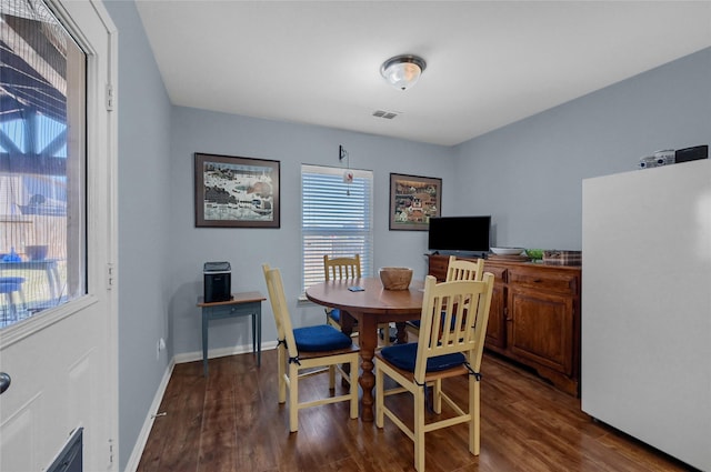 dining space featuring dark wood-type flooring, visible vents, and baseboards