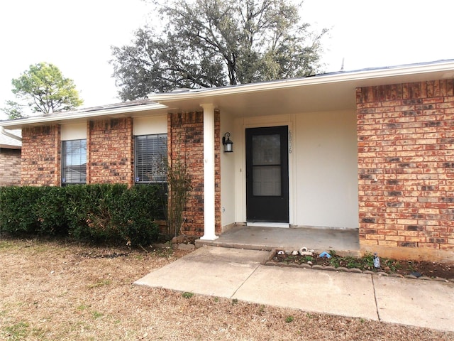 doorway to property featuring brick siding