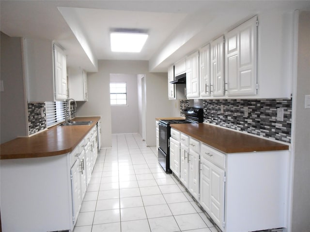 kitchen featuring light tile patterned floors, dark countertops, black range, under cabinet range hood, and a sink