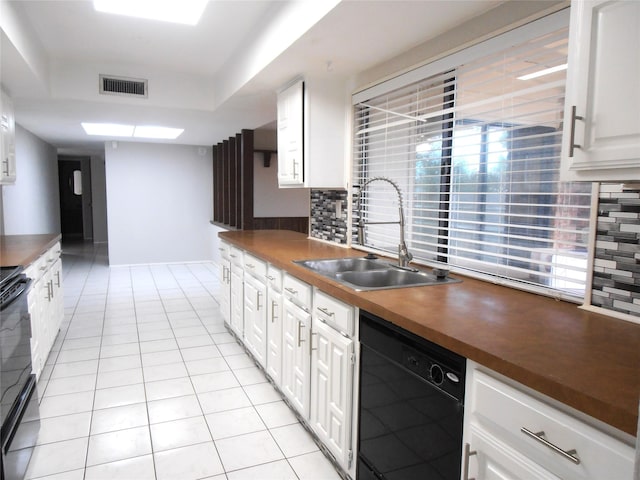 kitchen featuring black dishwasher, visible vents, decorative backsplash, white cabinets, and a sink