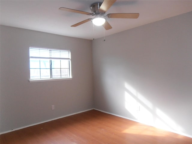 empty room featuring a ceiling fan, baseboards, and wood finished floors