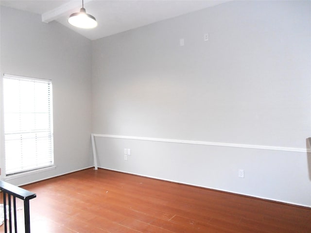 spare room with vaulted ceiling with beams and wood finished floors