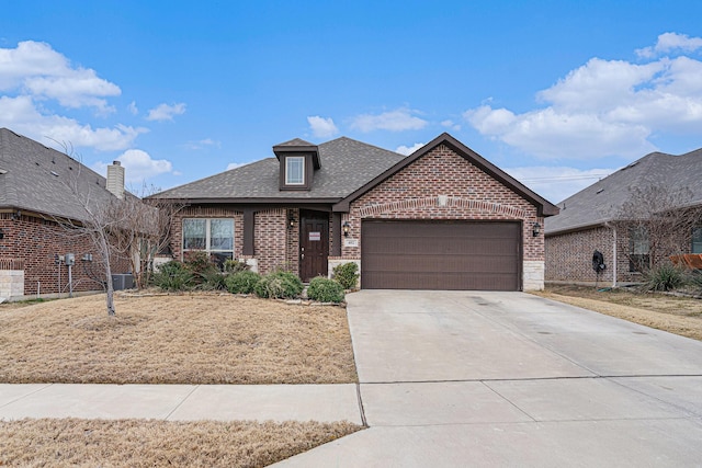 view of front of house with a garage, driveway, brick siding, and a shingled roof