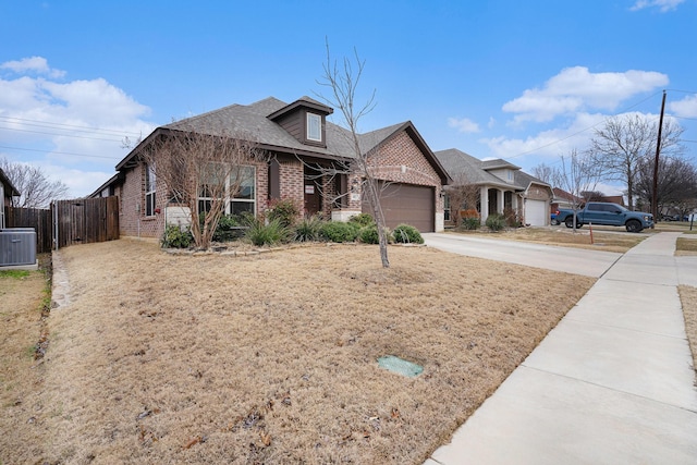 view of front facade with driveway, an attached garage, fence, central air condition unit, and brick siding