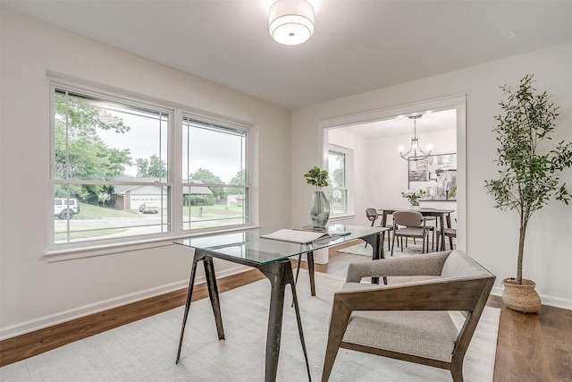 dining space with a chandelier, baseboards, and wood finished floors