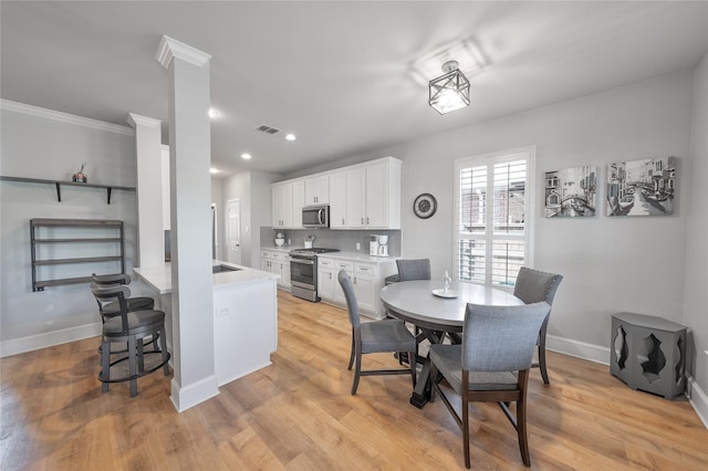 dining room with light wood-type flooring, visible vents, baseboards, and recessed lighting