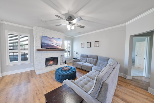 living area featuring light wood-style flooring, baseboards, and crown molding