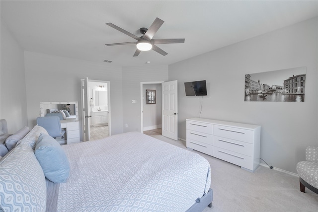 bedroom featuring light carpet, visible vents, baseboards, ensuite bath, and ceiling fan