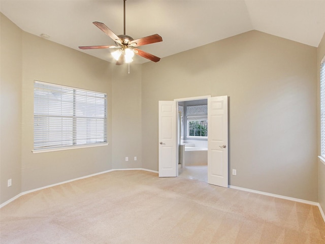 unfurnished bedroom with light carpet, multiple windows, and lofted ceiling