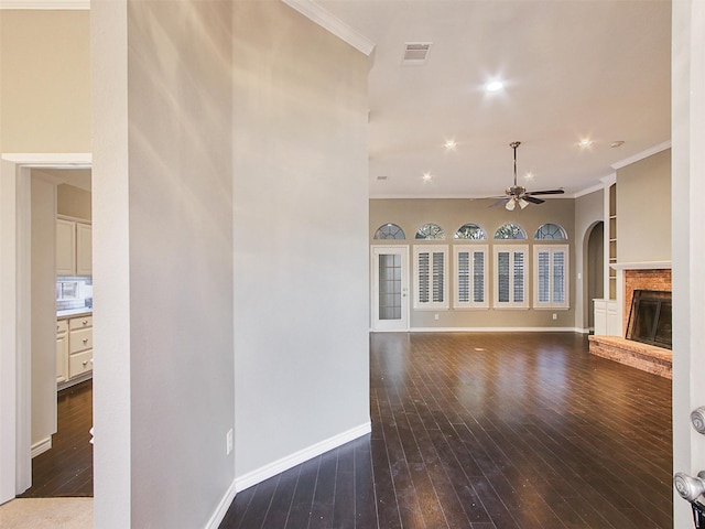 unfurnished living room with visible vents, dark wood-style flooring, and crown molding