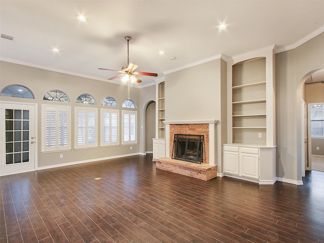 unfurnished living room featuring arched walkways, a fireplace, and baseboards