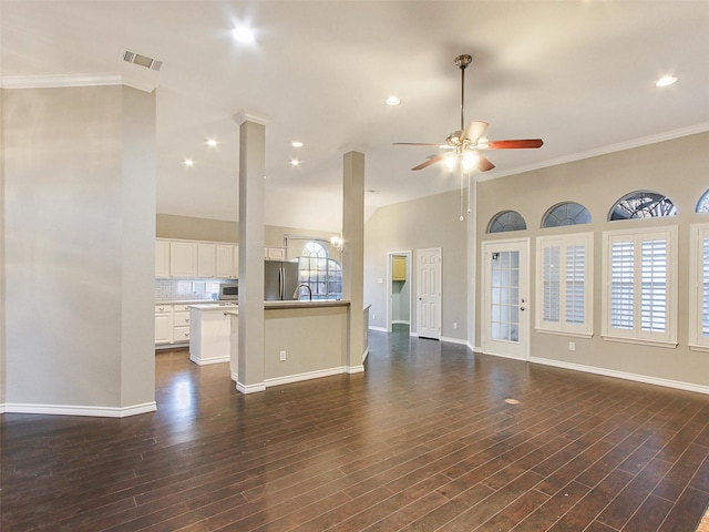 unfurnished living room with baseboards, visible vents, dark wood finished floors, a ceiling fan, and crown molding