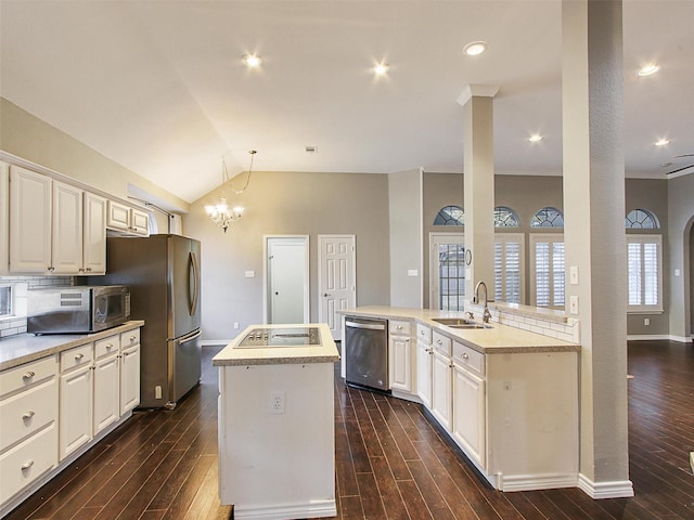 kitchen featuring a kitchen island, appliances with stainless steel finishes, dark wood-style flooring, and a sink