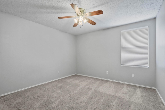 carpeted spare room featuring ceiling fan, a textured ceiling, and baseboards