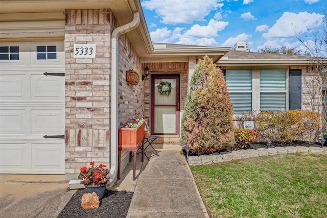 entrance to property featuring stone siding, brick siding, and an attached garage