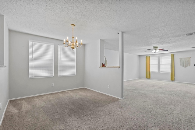 spare room featuring carpet flooring, visible vents, a textured ceiling, and ceiling fan with notable chandelier