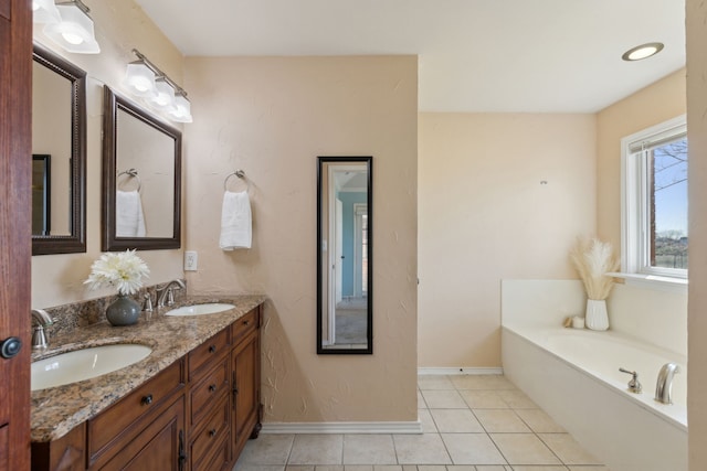 bathroom featuring a sink, double vanity, a bath, and tile patterned floors