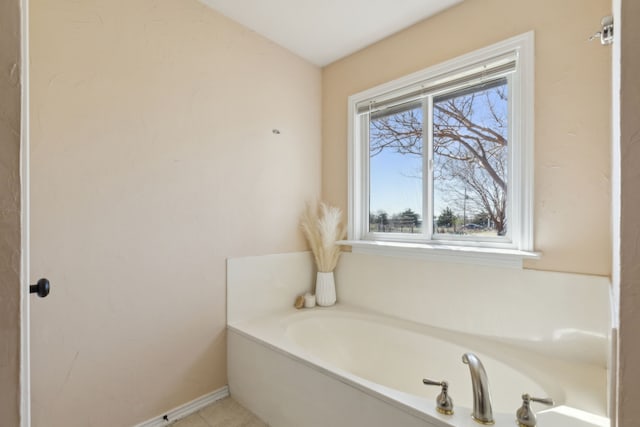 full bathroom with a garden tub and baseboards