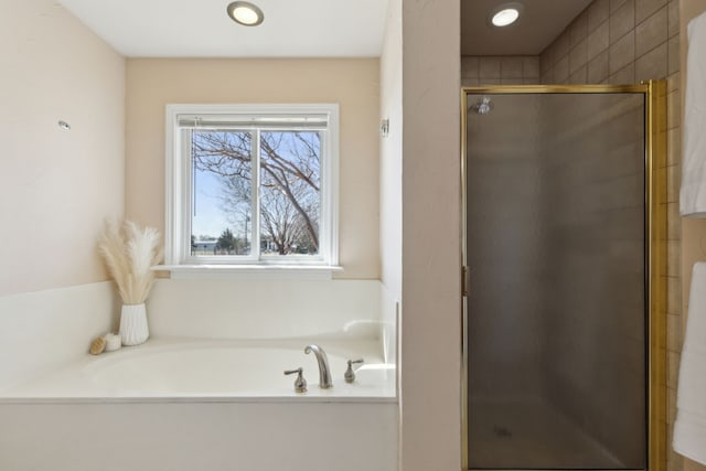 bathroom featuring a shower stall and a bath