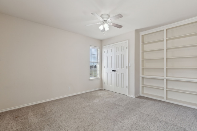 unfurnished bedroom with baseboards, carpet floors, and a ceiling fan