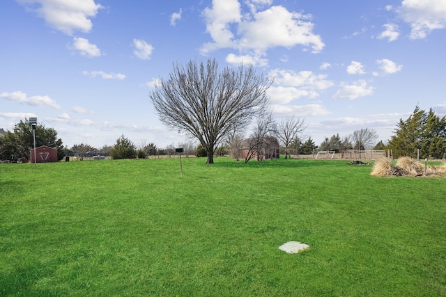 view of yard with an outbuilding, a rural view, and fence