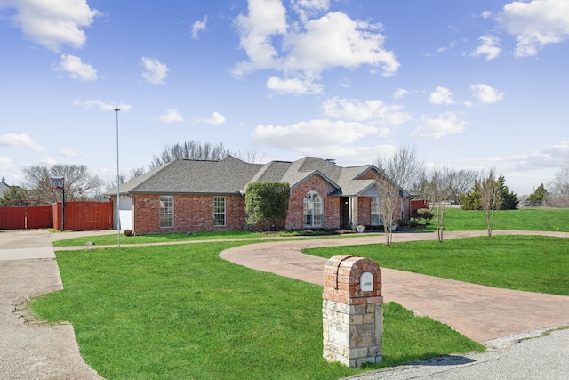 view of front of house featuring brick siding, concrete driveway, and a front yard